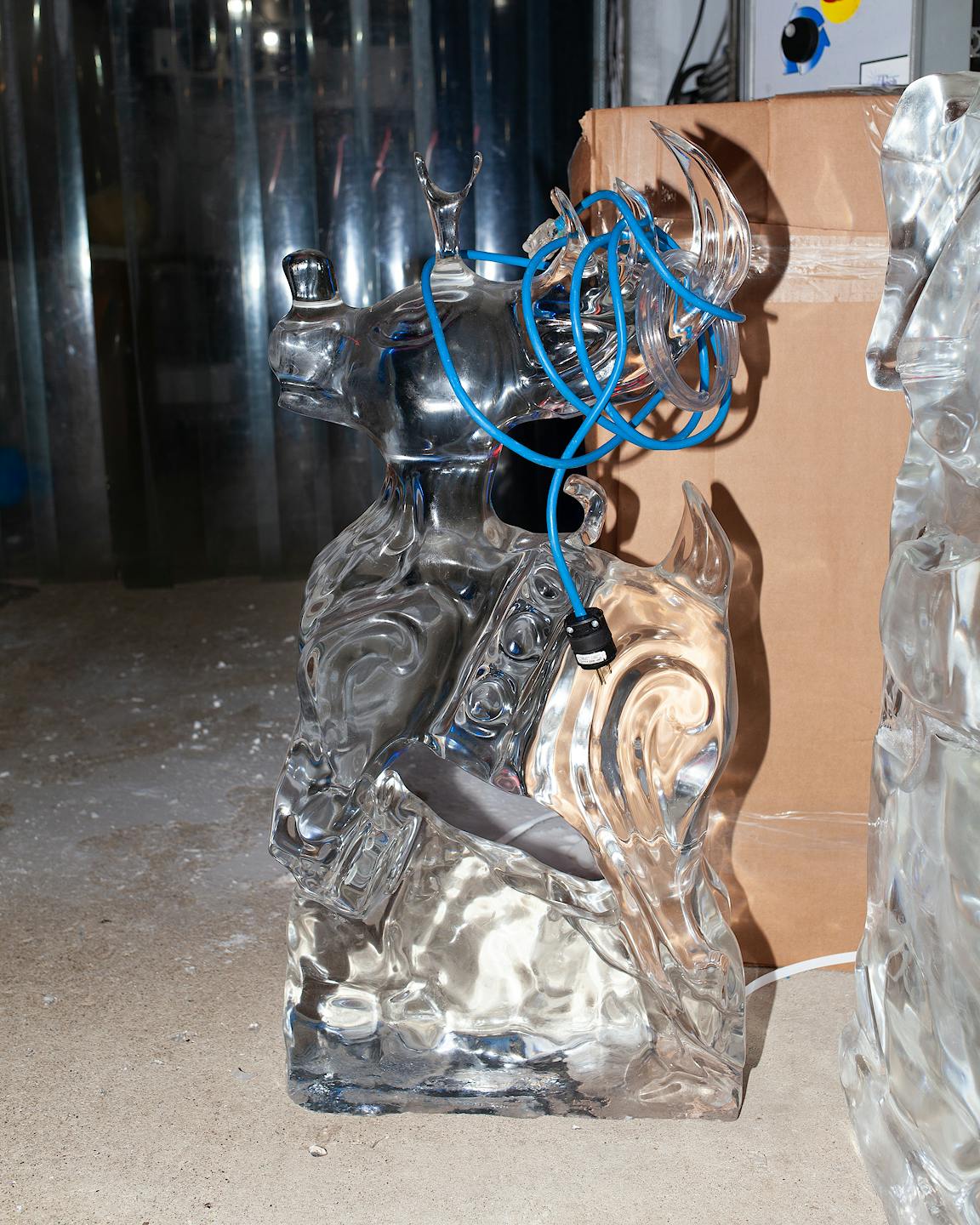 An ice sculpture of a reindeer with an electric light bulb nose.
